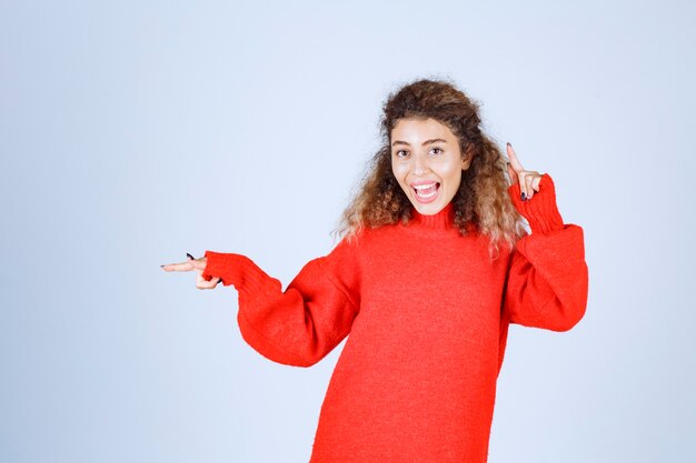 donna con i capelli ricci che punta al piano di sopra.