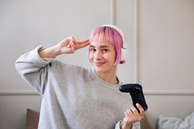 Donna con i capelli rosa che gioca a un videogioco