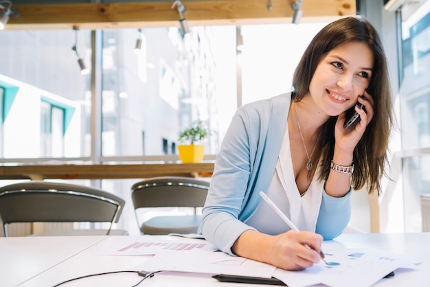 Donna con i diagrammi di correzione del telefono