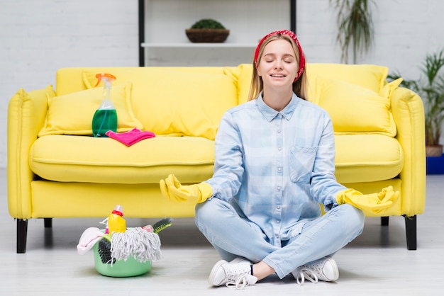 Donna con i guanti di pulizia che fanno yoga