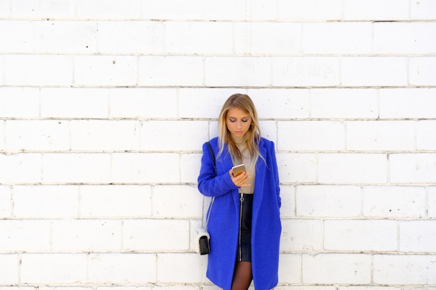 donna con il cappotto blu sulla strada