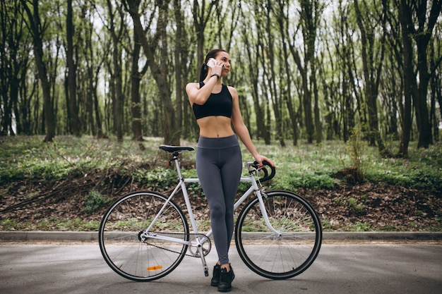 Donna con il cellulare in bicicletta