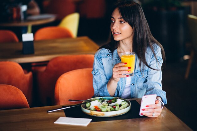 Donna con insalata e telefono