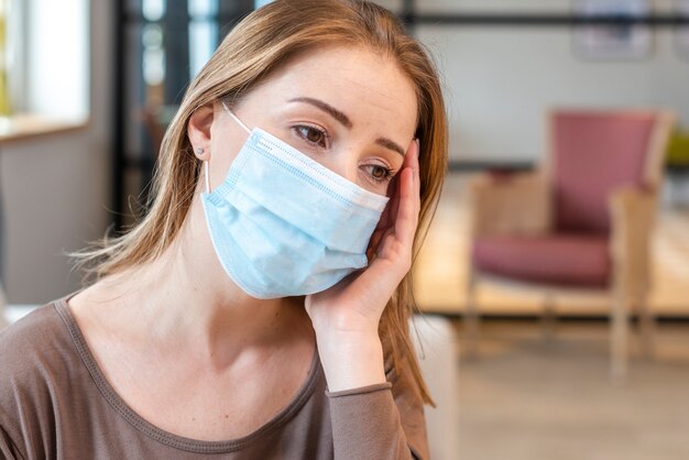 Donna con la maschera che resta in ritratto di quarantena