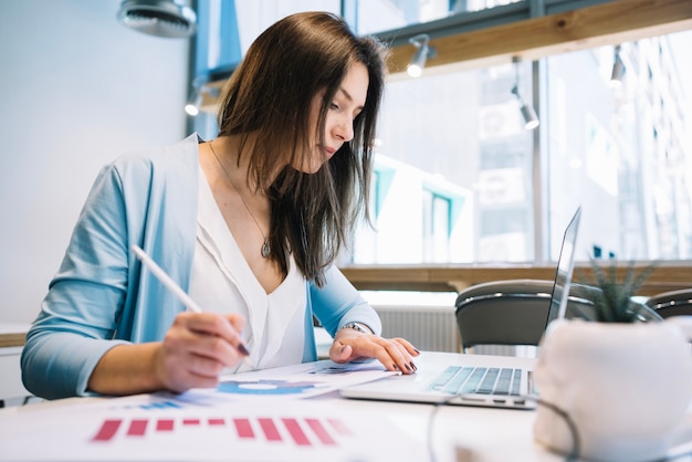 Donna con la penna con il computer portatile