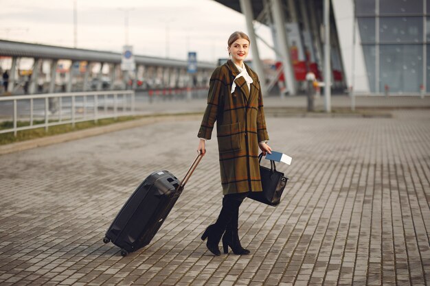 Donna con la valigia che fa una pausa l'aeroporto