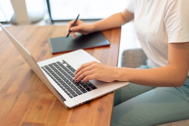 Donna con laptop che lavora da casa per allontanamento sociale