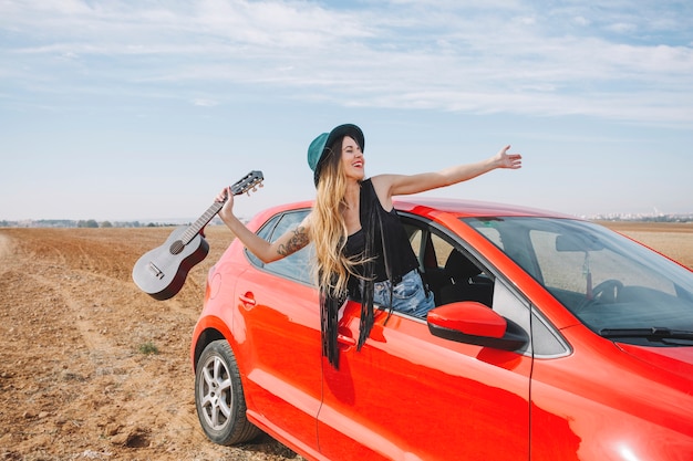 Donna con le ukulele nella finestra di automobile