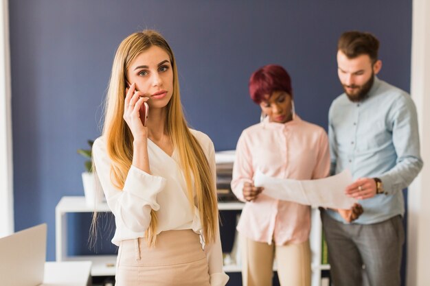 Donna con lo smartphone che guarda l&#39;obbiettivo