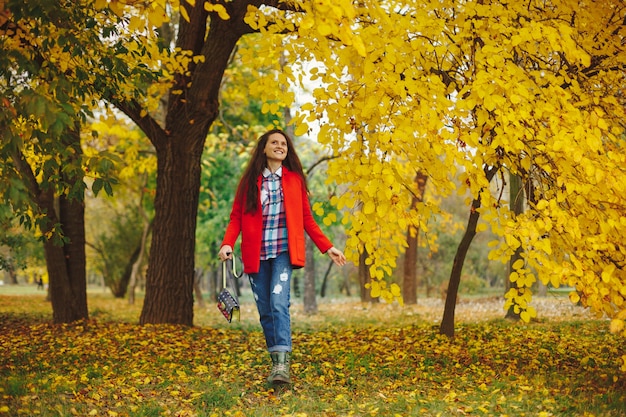 donna con lunghi capelli ondulati godendo l'autunno nel parco.