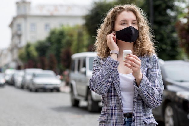 Donna con maschera all'aperto con airpods