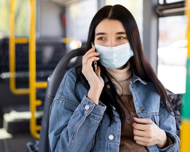 Donna con maschera che parla al telefono