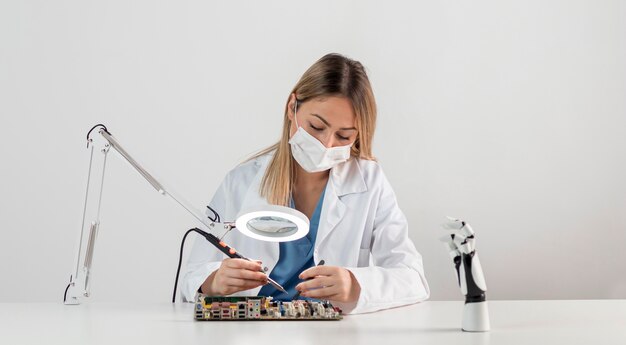 Donna con maschera facciale che lavora alla scrivania