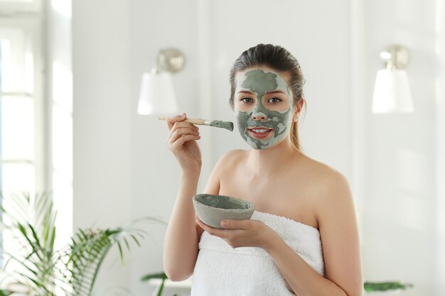 Donna con maschera facciale per la cura della pelle. Concetto di bellezza.