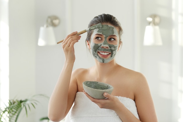 Donna con maschera facciale per la cura della pelle. Concetto di bellezza.