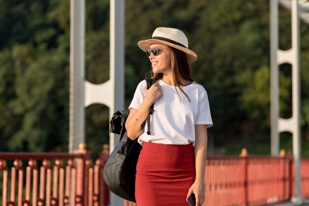 Donna con occhiali da sole e cappello che viaggiano da soli