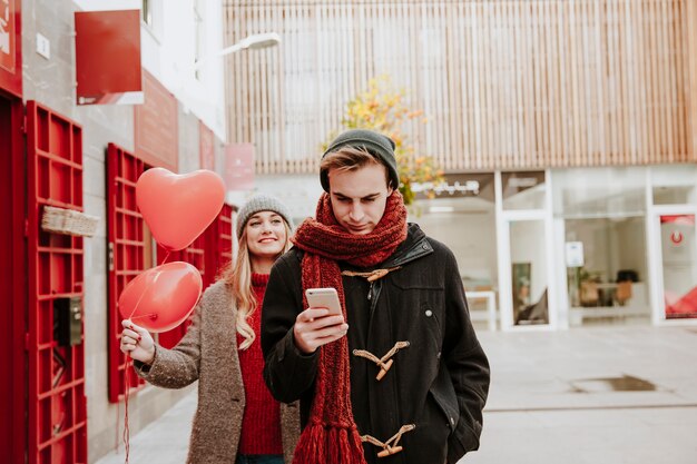 Donna con palloncini che arrivano all&#39;uomo con il telefono