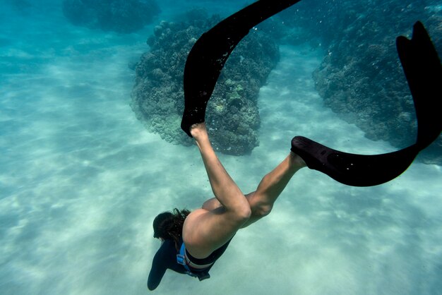 Donna con pinne nuotare nell'oceano