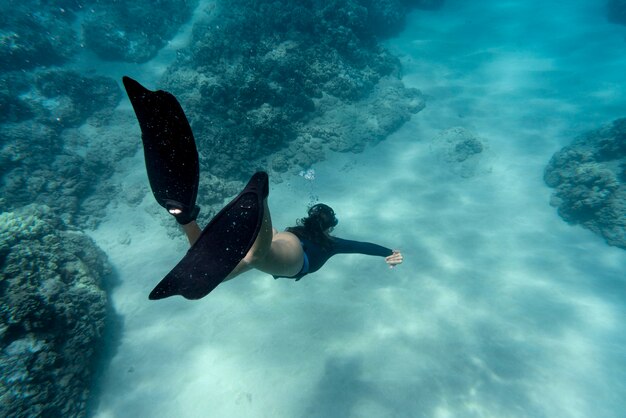 Donna con pinne nuotare nell'oceano