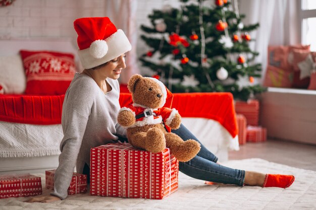 Donna con regali di Natale dall&#39;albero di Natale