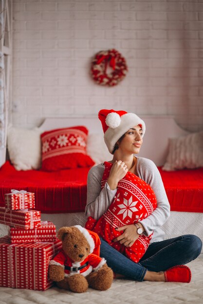 Donna con regali di Natale dall&#39;albero di Natale