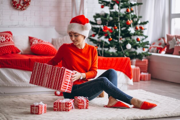 Donna con regali di Natale dall&#39;albero di Natale