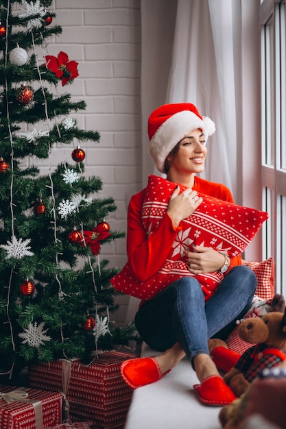 Donna con regali di Natale dall&#39;albero di Natale