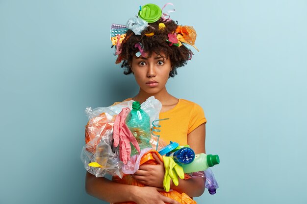 Donna con rifiuti di plastica in borsa a rete