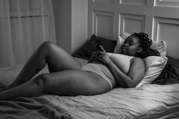 Donna con smartphone a letto a tutto campo