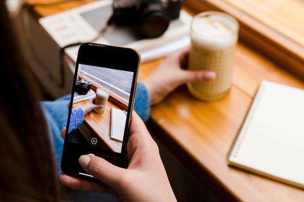 Donna con smartphone e tazza di caffè