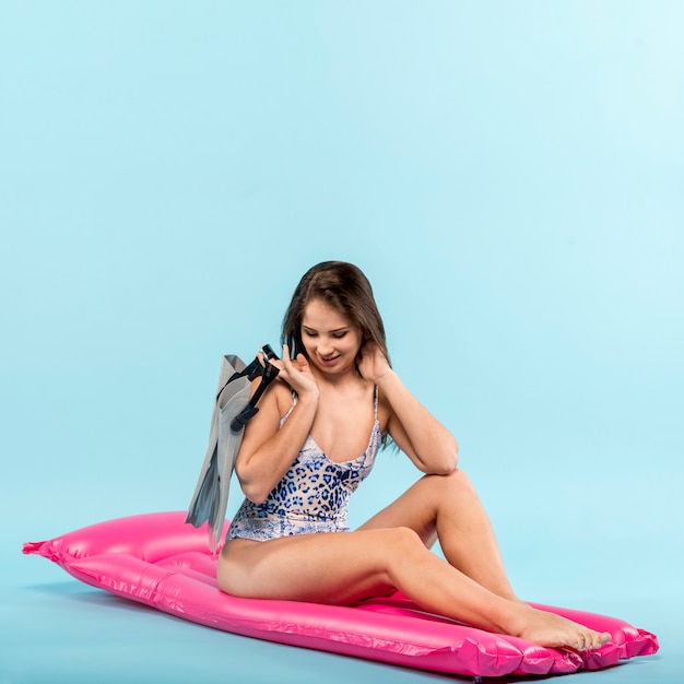 Donna con swimfins sul tappeto d&#39;aria rosa