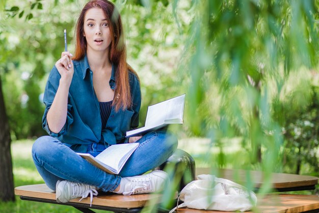 Donna con taccuini nel parco