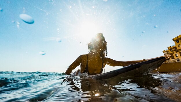 Donna con tavola da surf in acqua