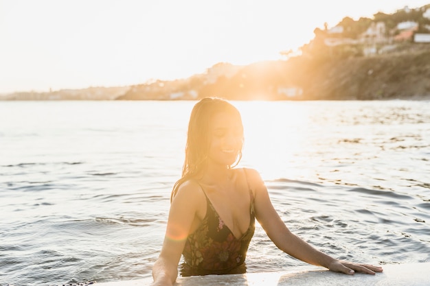 Donna con tavola da surf in spiaggia