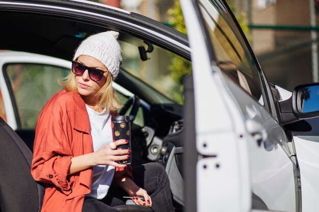 Donna con thermos in auto