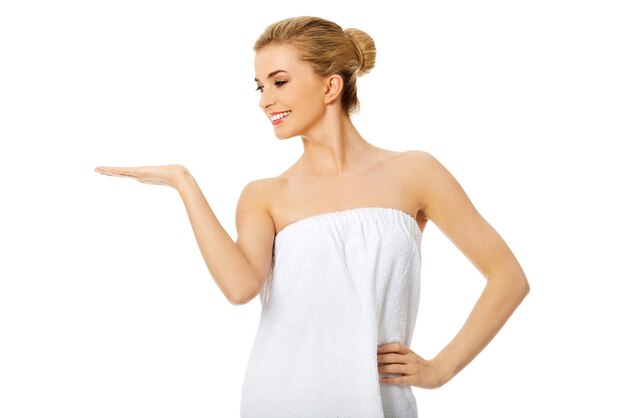 Donna con un asciugamano bianco che tiene la mano in alto per il posizionamento del prodotto o la pubblicità