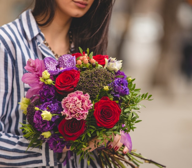 Donna con un bouquet colorato in strada