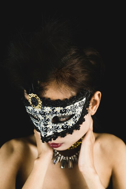 Donna con una maschera di carnevale su uno sfondo scuro