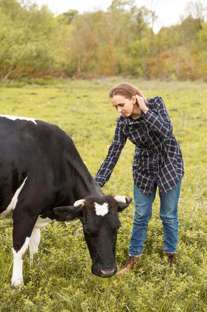 Donna con una mucca in fattoria