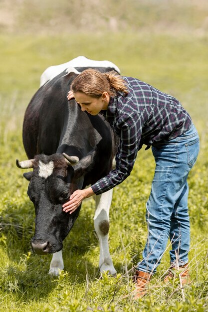 Donna con una mucca in fattoria