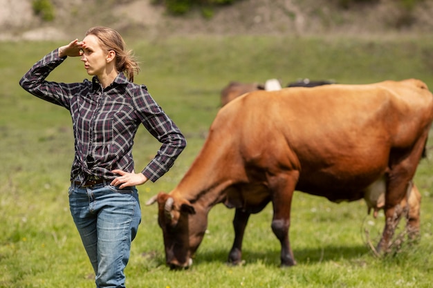 Donna con una mucca in fattoria