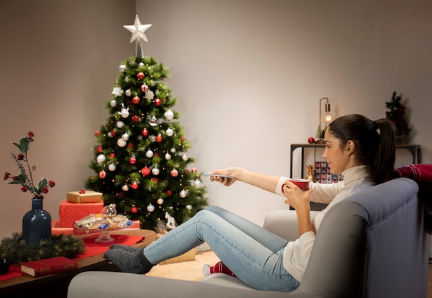 Donna con una tazza e una priorità bassa di natale