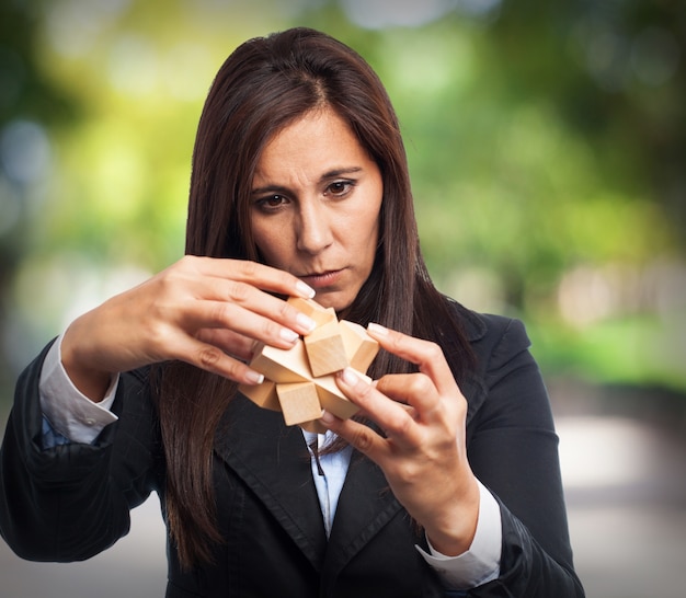 Donna con vestito la risoluzione di un gioco di intelligenza di legno