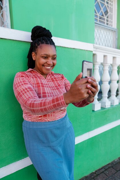 Donna con vista laterale che utilizza lo smartphone all'aperto