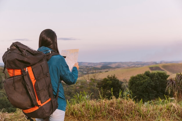 Donna con zaino da viaggio alla ricerca di mappa