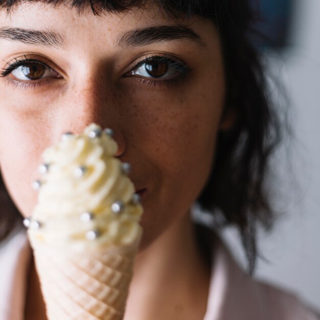 Donna cono gelato con argento cospargere davanti alla bocca