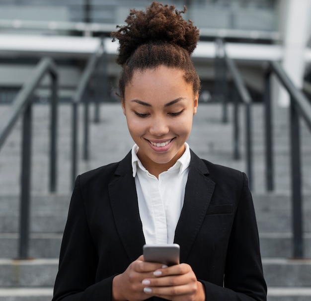 Donna corporativa che esamina telefono