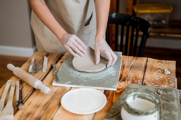 Donna creativa che fa una pentola di creta nel suo laboratorio