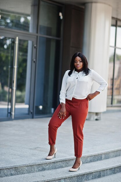 Donna d'affari afroamericana formalmente vestita in camicetta bianca e pantaloni rossi Imprenditrice di successo dalla pelle scura