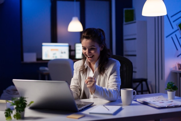 Donna d'affari che guarda un laptop professionale che lavora al progetto di grafici di marketing